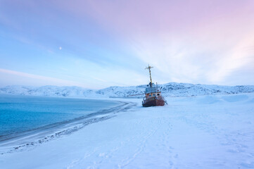 Beautiful seascape of Barents Sea with shipwreck of fishing boat on the shore in village Teriberka. Morning arctic winter landscape in Murmansk region of Russia