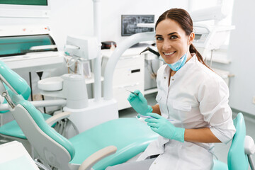 European mid dentist woman smiling while standing in dental clinic