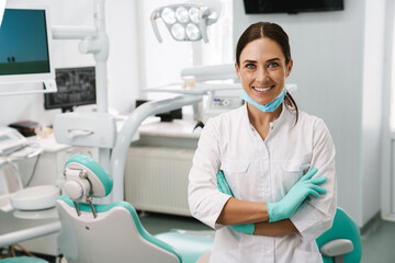 European mid dentist woman smiling while standing in dental clinic - obrazy, fototapety, plakaty