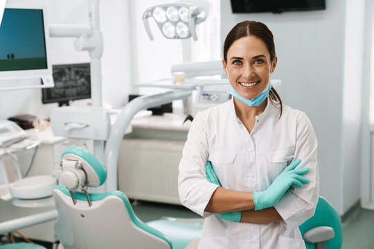 European mid dentist woman smiling while standing in dental clinic
