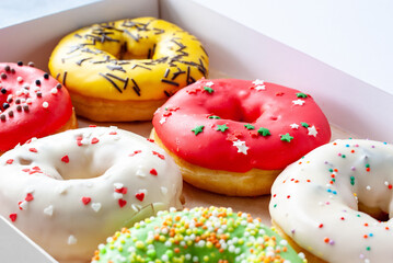 Assorted glazed sweet donuts closeup with selective focus