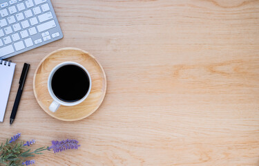 Workplace in office with wooden desk. Top view above of keyboard computer with notebook and pen. Space for modern creative work of designer. Flat lay with copy space. Business-finance concept.