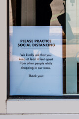 Social Distancing sign in shot window printed on white paper with a few bugs and some grunge - realistic.