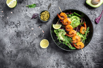 Buddha bowl with avocado, fresh salad, grilled shrimps and pesto sauce. keto diet. menu recipe place for text, top view