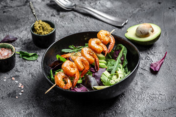 Vegetarian vegetable low carb lunch bowl with avocado, fresh salad, grilled shrimps and pesto sauce. Concept of healthy eating. top view