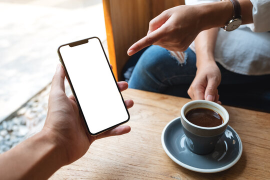 Mockup image of a woman pointing at a white mobile phone with blank black desktop screen in a man's hand