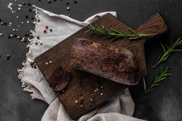 red smoked dry ham on a wooden cutting board