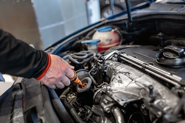 Fototapeta na wymiar Mechanic in a car repair shop checking the oil in a vehicle
