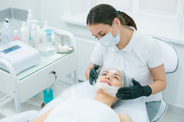Obraz na płótnie Canvas Mirthful lady enjoying skin therapy in modern clinic