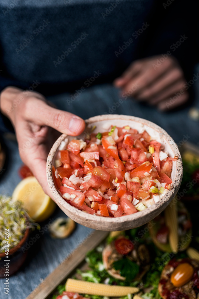 Poster man with a bowl of tomato salad in his hand