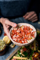 man with a bowl of tomato salad in his hand