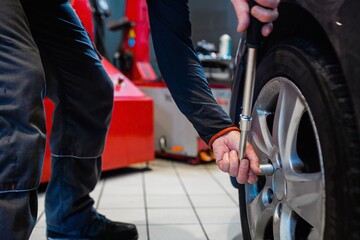 Mechanic in a car repair shop loosening the wheel nuts of a vehicle.