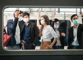 View through the window of passengers with face protection masks inside city trains from a platform...