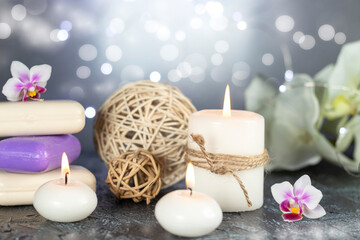 Spa resort therapy composition with burning candles, orchid flowers, soap, rattan balls and abstract lights. Concept of spa, relax or resort.