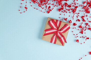 Gift, confetti, beads with hearts on pastel blue colors. Valentine's Day background. Valentine's Day concept. Flat lay. Top view. Copy space