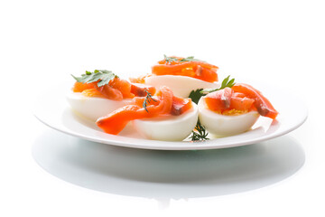 halves of boiled eggs with pieces of salted salmon on white background