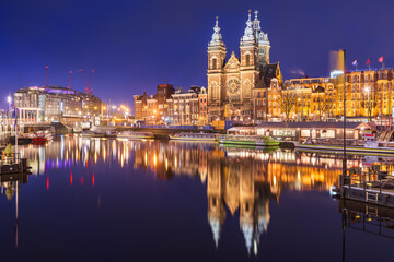 Amsterdam, Netherlands city center view with riverboats and the  Basilica of Saint Nicholas - obrazy, fototapety, plakaty
