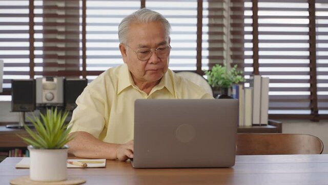 Asian old man Retirement age using tablet computer to transfer money online or financial payment and read text, smile or laugh with happy and positive. Senior asian with digital technology concept.