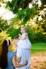 Happy family in the park evening light. The lights of a sun.