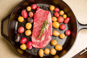 Red meat steak in a cast iron pan with potatoes
