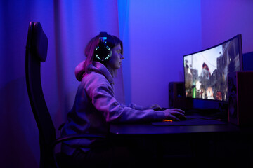 Young gamer girl sitting at pc - obrazy, fototapety, plakaty
