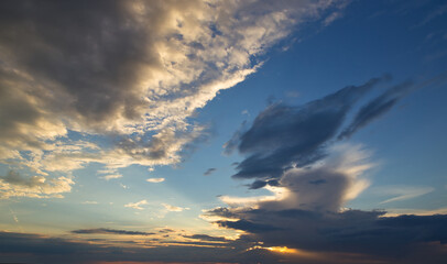 dramatic dark sky with rays and white clouds at sunset