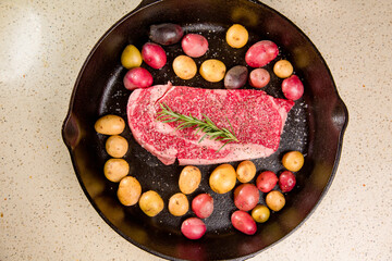 Red meat steak in a cast iron pan with potatoes