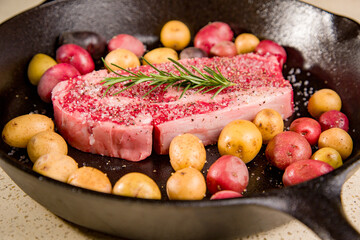Red meat steak in a cast iron pan with potatoes