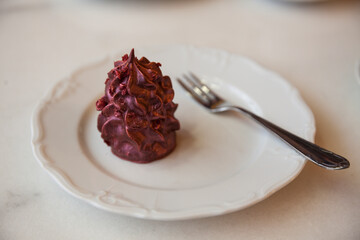 purple dessert on white porcelain plate and cup of coffee