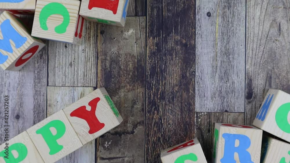 Poster colourful alphabet letters on wooden cubes with word - happy - in a diagonal line with additional bl