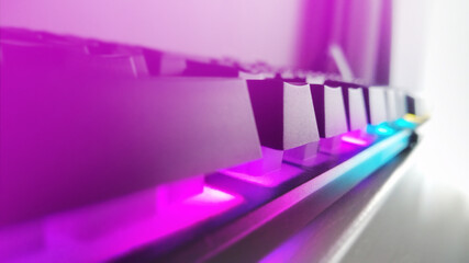 Professional cyber video gamer keyboard. Closeup of Gaming keyboard with LED illumination, backlit keyboard keyboard for stream in neon color blur background. Gaming work space concept.