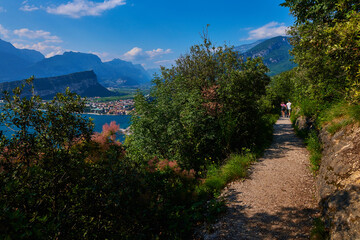 Panoramic view on Lake Garda from the Busatte-Tempesta trail near Nago-Torbole with the iron staircase,  Torbole  town surrounded by mountains in the summer time,Italy