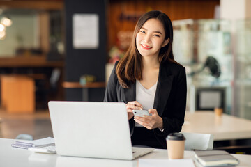 Portrait of Asian young female working on laptop at office