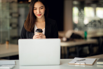 Portrait of Asian young female working on laptop 