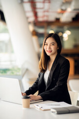 Portrait of Asian young female working on laptop at office