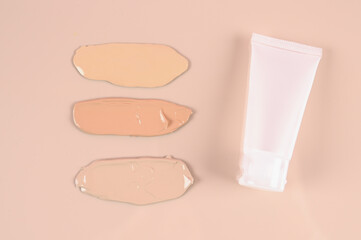 Makeup product smears on pink background. Color set of foundation, top view