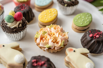 cute colorful spring easter egg shape cake tartlet muffin cupcake with yellow tulips easter concept 
