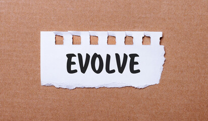 On a brown background, white paper with the inscription EVOLVE