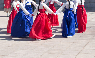 Womans wearing Hanbok, a traditional Korean costume, are performing traditional Korean circle dance play.