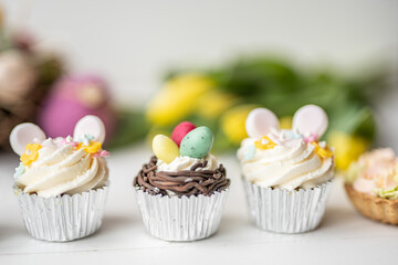 cute colorful spring easter egg shape cake tartlet muffin cupcake with yellow tulips easter concept 