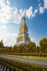 Naklejka premium The Pagoda of Wat Phra That Panom temple in Nakhon Phanom, Thailand in cloudy blue sky day with sunlight