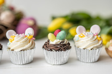 cute colorful spring easter egg shape cake tartlet muffin cupcake with yellow tulips easter concept 