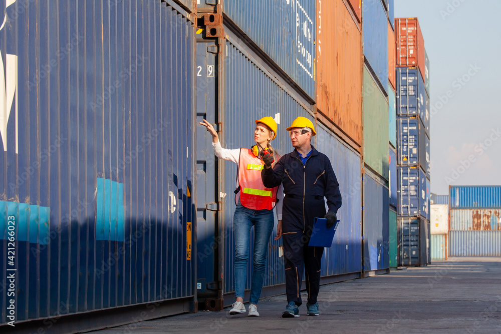 Poster working engineer in the construction container yard. worker and supervisor checking containers data.