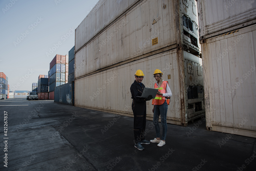Poster working engineer in the construction container yard. worker and supervisor checking containers data.