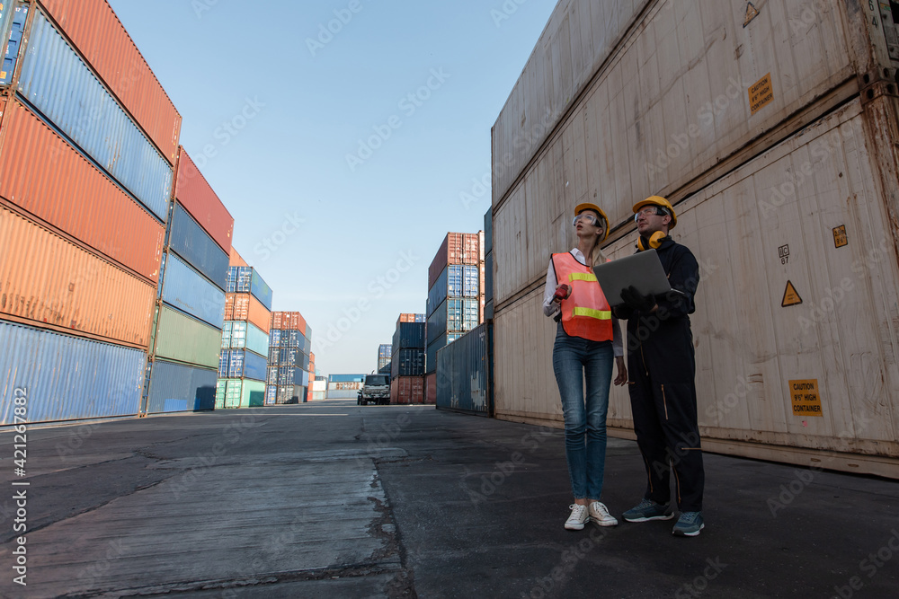 Poster working engineer in the construction container yard. worker and supervisor checking containers data.