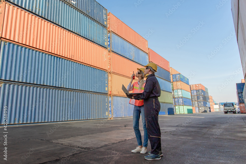 Poster working engineer in the construction container yard. worker and supervisor checking containers data.