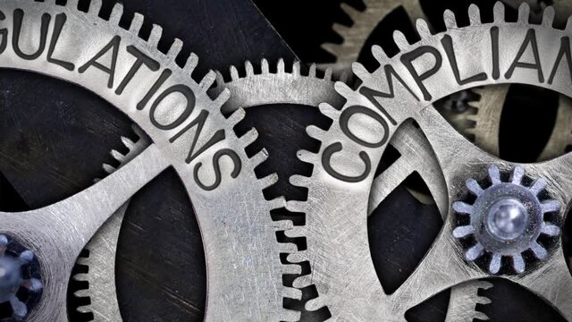 Group of rotating tooth wheels with Regulations and Compliance sign imprinted on metal surface. High quality 4k video.