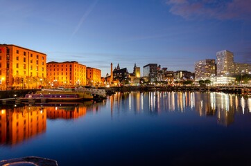 Naklejka premium Liverpools Albert Dock in the evening with its buiding reflecting in to the docks still water