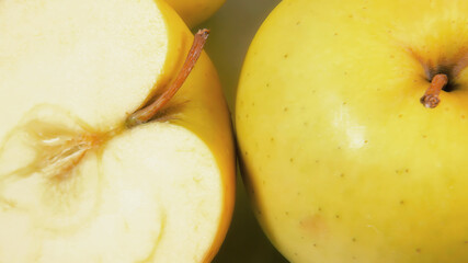 Naklejka na ściany i meble Yellow apples, both whole and cut in half. Above detail shot. 