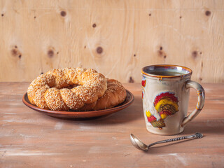 Morning tea with large butter rolls on a ceramic plate o
